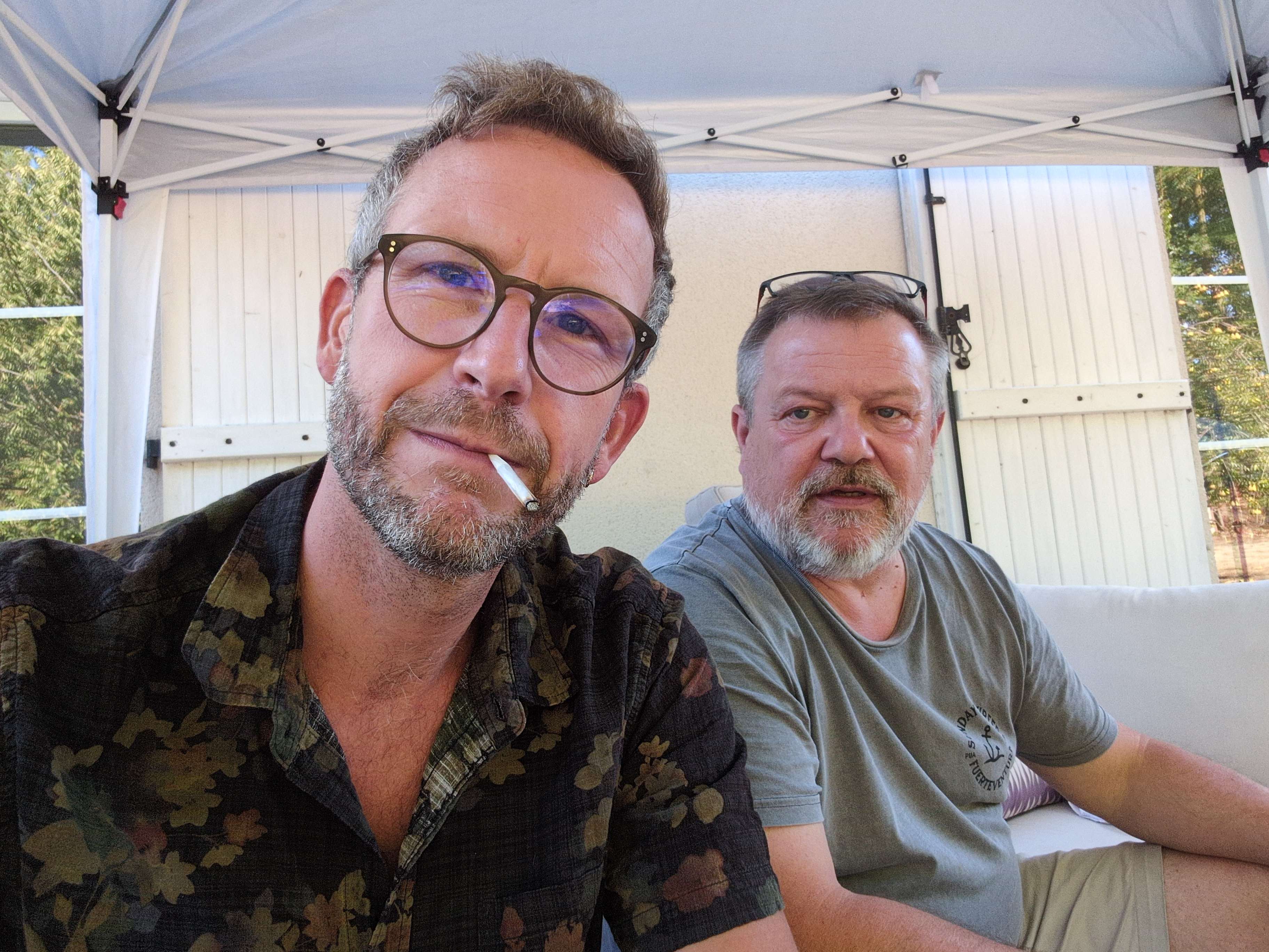 Deux amis sous une tonnelle, réunis autour d’un moment convivial